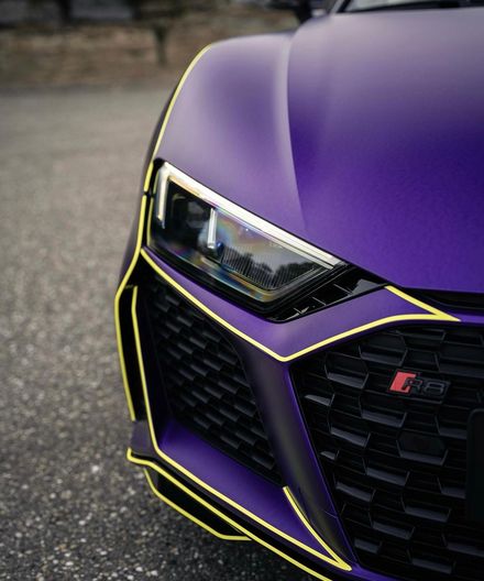 Front eines mattvioletten Audi R8 mit gelber Zierlinie