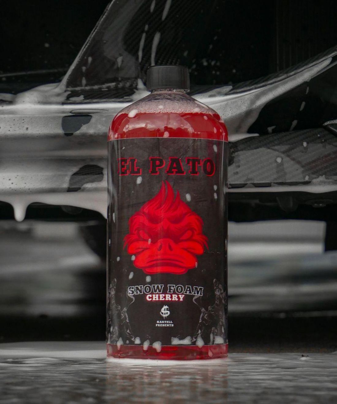 El Pato Snow Foam Cherry vor einem eingeschäumten Sportwagen
